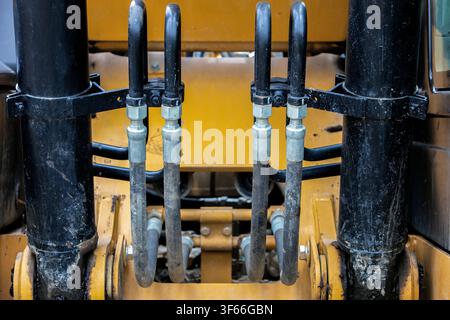 Prima pianura su tubi e connettori idraulici su una pala meccanica Foto Stock