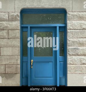 Ingresso a pannelli blu con lati in vetro e timpano arrotondato è inserito in una facciata in pietra chiara strutturata a Chicago. Foto Stock