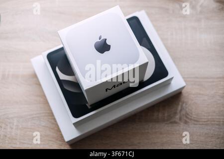 Scatola Mac con logo Apple posizionata su scatole impilate di iPad e MacBook su un tavolo di legno. Impilamento di prodotti Apple mac ipad, mac mini ipad air macbook, apple Foto Stock