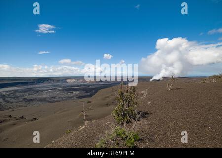 Scattata dall'Uekahuna Overlook all'interno del Parco Nazionale dei Vulcani delle Hawaii, questa veduta mostra la vasta caldera di Kīlauea. La luce del sole illumina il Foto Stock