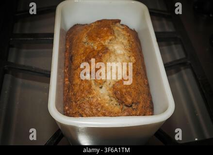 Pane di banana fatto in casa appena sfornato che si raffredda in una teglia vintage su un fornello da cucina Foto Stock