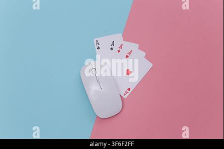 Casino online. Mouse per PC e quattro assi su sfondo rosa blu. Vista dall'alto Foto Stock