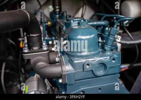 Testa del cilindro di un motore diesel industriale con coprivalvole e linee di iniezione del carburante che illustra l'ingegneria delle macchine pesanti e la trasmissione di potenza Foto Stock