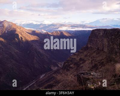 Valle montana e scogliera frastagliata che si affaccia su cime innevate in lontananza, Canyon Debed. Lori Providence, Armenia Foto Stock
