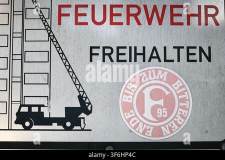 Düsseldorf, Germania, 21.05.2026 Un adesivo con il logo del club Fortuna Düsseldorf è attaccato a un cartello stradale che indica la via di fuga dei vigili del fuoco a Düsseldorf - Mörsenbroich Foto: Norbert Schmidt, Düsseldorf Foto Stock