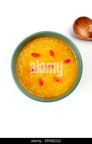 Porridge di miglio dorato e zucca guarnito con bacche di goji essiccate Foto Stock