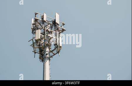Prima di un'antenna per telecomunicazioni con antenne sullo sfondo di un cielo sereno Foto Stock