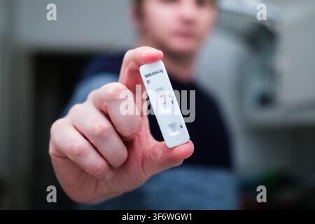 Mano che tiene una cassetta del test rapido per antigeni Sars-Cov-2 che mostra un risultato positivo Foto Stock