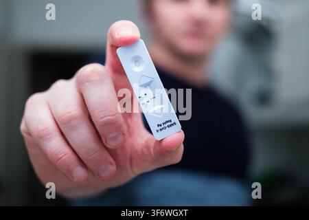 Una persona tiene una cassetta del test rapido per antigeni COVID-19 che riporta un risultato negativo Foto Stock