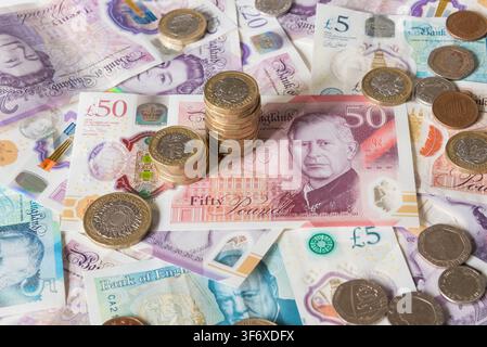 Banconote e monete in sterline britanniche Foto Stock