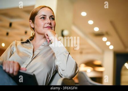 Donna professionale con laptop in un caffé moderno Foto Stock