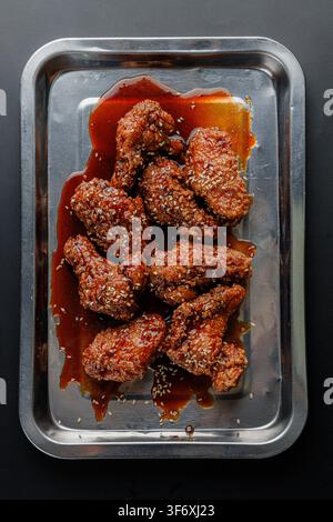 Pollo fritto alla salsa coreana su un vassoio Foto Stock