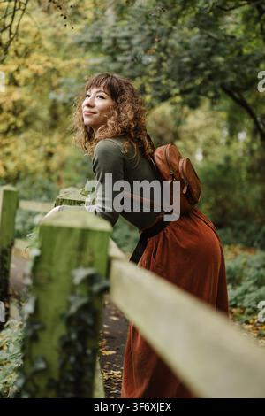 Giovane donna con zaino che si gode una passeggiata autunnale Foto Stock
