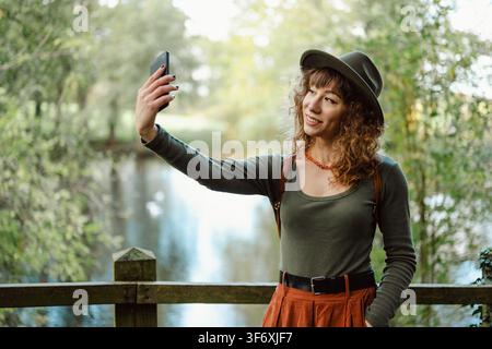 Felice giovane donna prendendo un selfie all'aperto Foto Stock