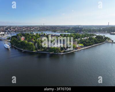 Vista aerea dell'isola di Skeppsholmen con i suoi edifici storici, alberi lussureggianti e le acque del porto circostante a Stoccolma, contea di Stoccolma, Svezia Foto Stock