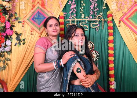 Madre e figlia in posa insieme sul palco decorato della cerimonia Mehndi durante un matrimonio indiano a Patna, Bihar, India. Uso editoriale solo. Foto Stock
