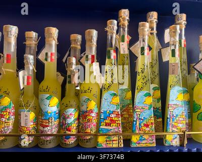 Bottiglie di limoncello prodotto localmente dipinte a mano con motivi di Positano in vendita in un negozio sulla Costiera Amalfitana, Campania, Italia meridionale. Foto Stock