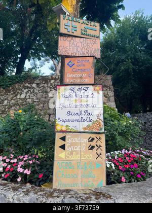 Segnaletti direzionali colorati dipinti a mano per i negozi locali, Villa Rufolo e Chiesa dell'Annunziata nella storica città collinare di Ravello, Italia. Foto Stock