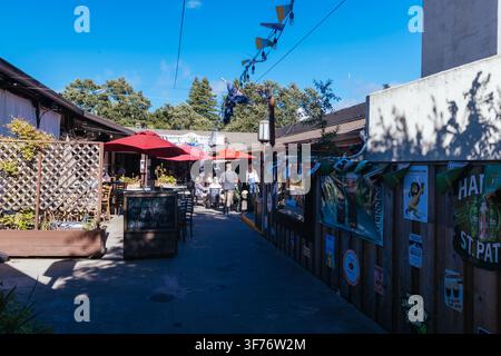 Area da pranzo all'aperto con ombrelloni rossi e persone a Sonoma, California Foto Stock