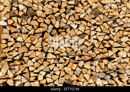 Texture di vista frontale pulita di tronchi di legno spaccati impilati strettamente in una catasta di legna. Foto Stock