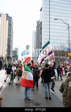 Toronto, Ontario - 14 febbraio 2026: Protesta della diaspora iraniana con bandiere su Yonge Street Foto Stock
