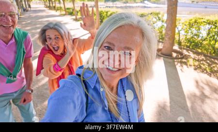 Amici anziani che si fanno un selfie e salutano all'aperto nel parco Foto Stock