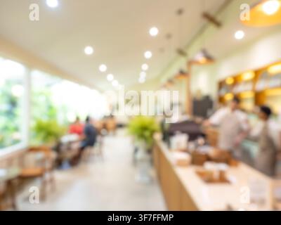 Interno sfocato di un caffè con bancone del bar, illuminazione calda e clienti in messa a fuoco morbida, creando uno sfondo accogliente per ospitalità, ristorante, cof Foto Stock