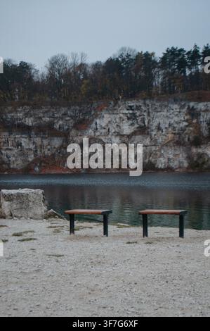 Due panchine che si affacciano su un tranquillo lago Foto Stock