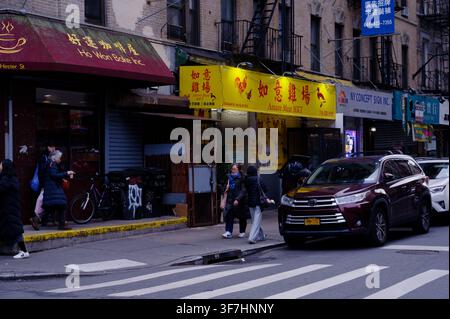 I pedoni passano davanti a un'insegna gialla brillante di un macello in Elizabeth Street, Chinatown Foto Stock