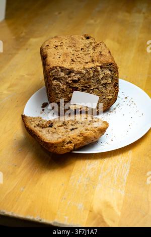 Panino integrale fatto in casa con una fetta affettata su un piatto bianco Foto Stock