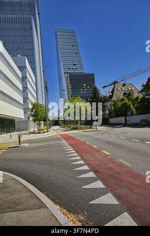 Scena cittadina con pista ciclabile davanti ad edifici moderni in una giornata soleggiata, grattacieli Roche, torre, architettura, Herzog de Meuron, edificio più alto i Foto Stock