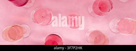 Panorama di degustazione di vini rosa, foto a cielo aperto, una varietà di tonalità e tinte, su sfondo rosa, molti bicchieri da vino, striscione panoramico Foto Stock