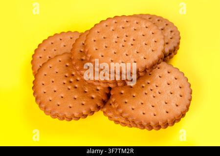 Biscotti rotondi con ripieno su uno sfondo giallo. Un mazzo di biscotti dolci ripieni di cacao. Foto Stock