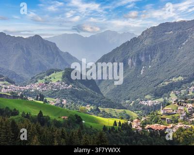 Panorama di una valle alpina con villaggi di montagna e prati verdi in estate, Oltre il Colle, Bergamo, Lombardia, Italia Foto Stock