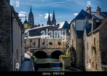 Una vista pittoresca del fiume Aure con un vecchio mulino e la cattedrale nella città storica di Bayeux in Normandia, Francia. Foto Stock
