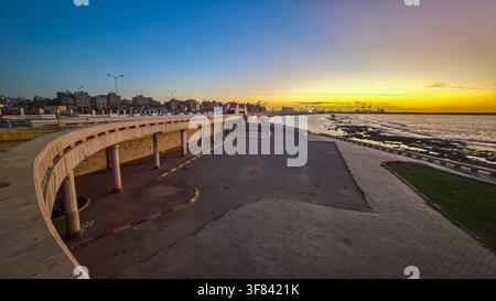 Tramonto lungo il lungomare di Bengasi, Libia con lo skyline della città visibile sullo sfondo Foto Stock
