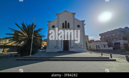Vecchia chiesa si erge a Tobruk circondata da edifici moderni e un cielo luminoso in Etiopia Foto Stock