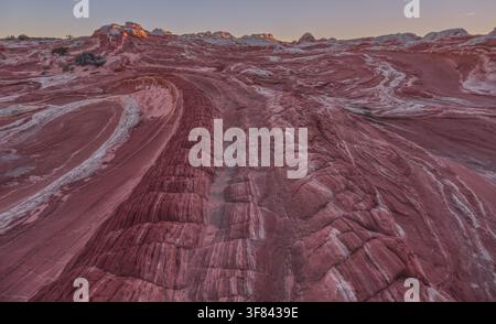 Formazioni di arenaria colorate a White Pocket interagiscono con la luce durante il tramonto sull'altopiano di Paria in Arizona Foto Stock