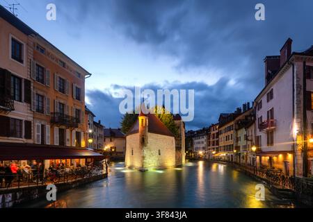 Illuminazione del Palais de lIsle sul canale del fiume Thiou ad Annecy durante le ore del crepuscolo Foto Stock