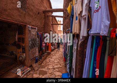 Vicolo stretto pieno di prodotti locali in un mercato ad Ait Ben Haddou in un pomeriggio nuvoloso Foto Stock
