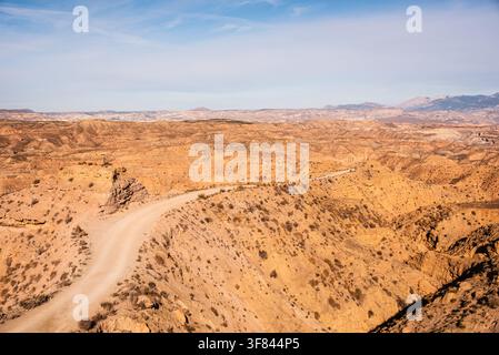 Sentiero desertico che si snoda attraverso terre erose in una regione arida della Spagna Foto Stock