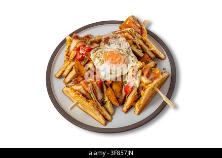 Club Sandwich con uovo fritto, pollo, pancetta, pomodoro, patatine Wedges e pane tostato su piatto Foto Stock