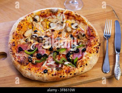 Pizza doppia servita su tavola di legno Foto Stock