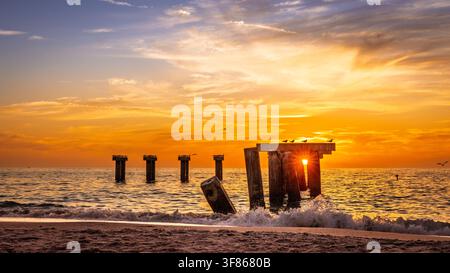 Il sole tramonta dietro i resti del molo di Boca grande, Florida Foto Stock
