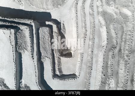 Vista aerea di una cava a cielo aperto che mostra livelli terrazzati, strade di scavo e operazioni minerarie industriali. Concetto di estrazione minerale, pesante Foto Stock