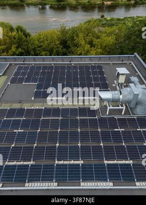 Vista aerea ravvicinata di un array di pannelli solari montati a file su un tetto commerciale piatto, concetto di dettaglio di installazione di energia rinnovabile e fotovoltaica. Foto Stock
