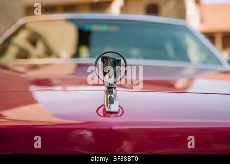Lindau, Svizzera, 9 agosto 2026. Primo piano dettagliato che mostra l’ornamento del cofano a triplo scudo in cromo e smalto montato sul cofano rosso lucido di Foto Stock