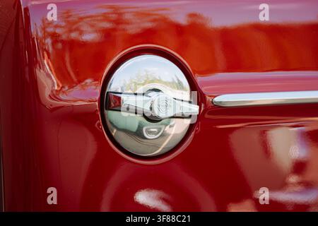 Lindau, Svizzera, 9 agosto 2026. Primo piano dettagliato di un tappo del serbatoio rotondo in cromo con maniglia con emblema Volvo, inserito nella carrozzeria dipinta di rosso di un cl Foto Stock