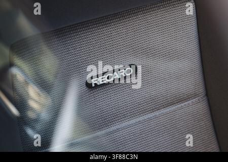 Lindau, Svizzera, 9 agosto 2026. Primo piano dettagliato dell'emblema del produttore Recaro attaccato a una tappezzeria grigia strutturata su buc ad alte prestazioni Foto Stock