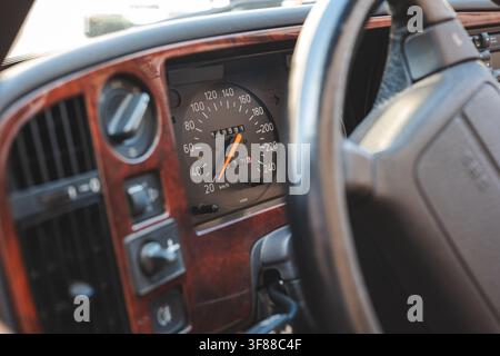 Lindau, Svizzera, 9 agosto 2026. Primo piano dettagliato con finiture del cruscotto a grana di legno, indicatore di velocità analogico e volante in classe Foto Stock